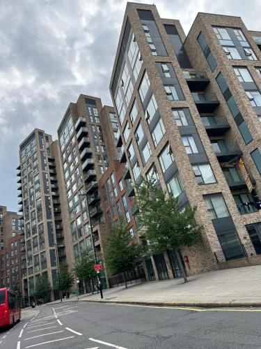 a tall building on a city street with a red bus at Santina Apartments in Croydon