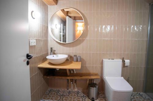 La salle de bains est pourvue d'un lavabo, de toilettes et d'un miroir. dans l'établissement Paorra Baserria, à Aia