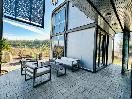 a patio with a bench and tables and windows at Cubos de Chacras AZUL in Mendoza