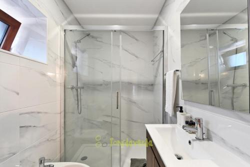 uma casa de banho com um chuveiro, um WC e um lavatório. em Casa do Alfaiate by TonsdeVerde em Vila Verde