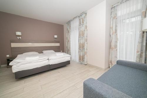 a bedroom with two beds and a couch at VacationClub – Tignes Apartament 2 in Sienna