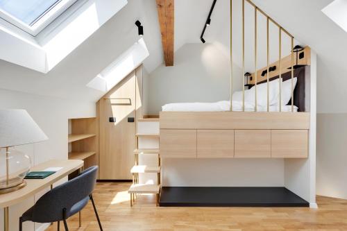 a bedroom with a loft bed and a desk and chair at Bloom Hotel in Ljubljana
