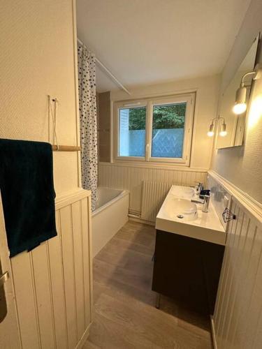 une salle de bain avec un lavabo et une baignoire dans l'établissement Appartement 4 pers. avec parking gratuit sur place Petit Couronne, à Le Petit-Couronne
