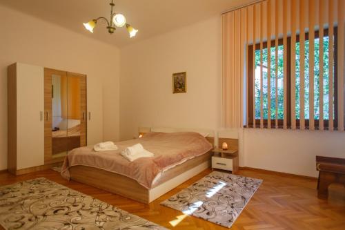 a bedroom with a bed and a large window at Barok Appart in Braşov