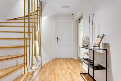 a hallway with a staircase with gold railings at Bloom Hotel in Ljubljana