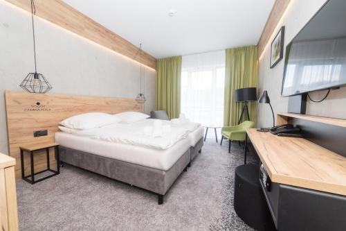pokój hotelowy z łóżkiem i telewizorem z płaskim ekranem w obiekcie VacationClub - Czarna Perła Apartament 303 w Stroniu Śląskim