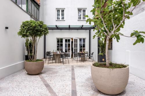 a courtyard with two large pots with trees in it at Bloom Hotel in Ljubljana