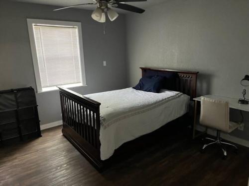 a bedroom with a bed and a desk and a ceiling fan at Gilcrease Hillside in Tulsa