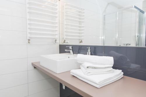 bagno bianco con lavandino e specchio di VacationClub - Solden Apartament 29 a Sienna