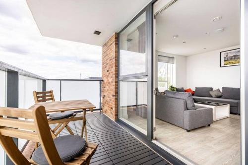 Stylish & Comfortable Top-Floor Flat in Harrow في لندن: غرفة معيشة مع طاولة وأريكة