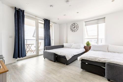1 Schlafzimmer mit 2 Betten und einem großen Fenster in der Unterkunft Stylish & Comfortable Top-Floor Flat in Harrow in London