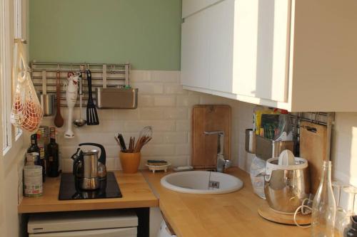 eine Küche mit einer Arbeitsplatte und einem Waschbecken in der Unterkunft Appartement 2 pièces tout équipé in Montreuil