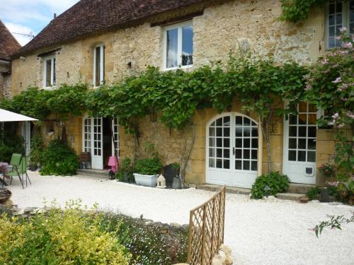 une maison en pierre avec une clôture devant elle dans l'établissement Residence Beausejour, à Saint-Cyprien