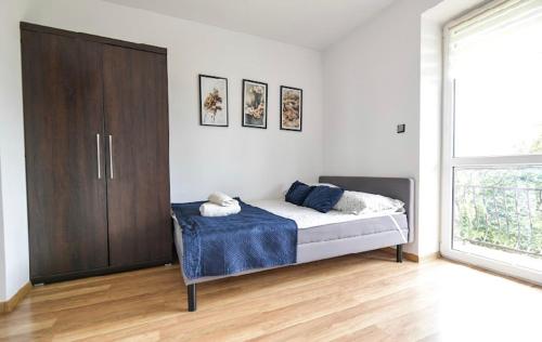 a bedroom with a bed and a wooden cabinet at Noclegi u Majki in Zator