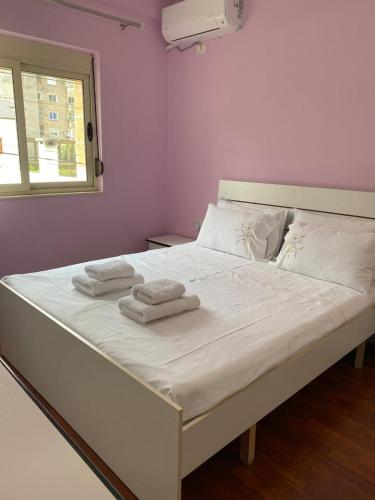 a large white bed with two towels on it at Dhimitrulla Guest-House in Përmet