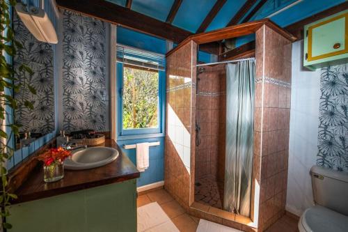 uma casa de banho com um lavatório e um chuveiro em Arevareva Pole House Papeete em Papeete