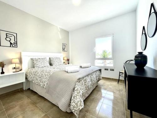 um quarto branco com uma cama e uma secretária em Iris Apartamento em Arrieta