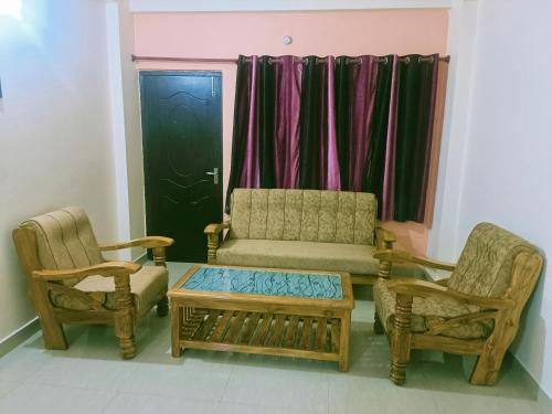 a living room with two chairs and a couch at Pretty Garden View Apartment 3BHK Furnished Flat near Kashi Vishwanath Temple in Varanasi