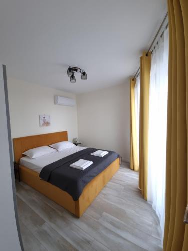 a bedroom with a bed and a large window at Апартамент Орех А30 in Varna City