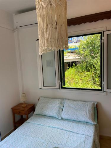 Schlafzimmer mit einem Bett und einem Fenster in der Unterkunft The view in Poros