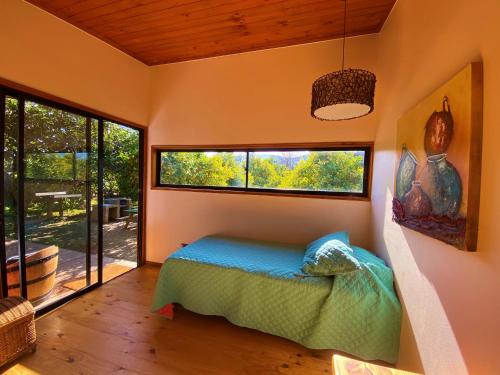 a bedroom with a bed and a large window at Cabañas SPA Olmue in Olmué