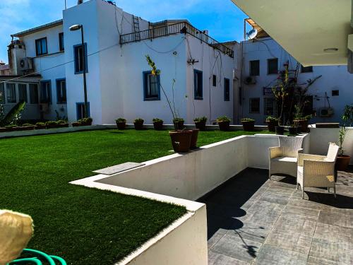 a backyard with a lawn with chairs and a building at BD Suites in Bodrum City
