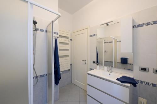 a white bathroom with a sink and a shower at TulipHouse da Davide in Bologna