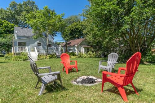 four chairs sitting in the grass in a yard at Town & Trail - Walkable Wellington Charmer in Wellington