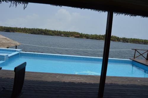 einen Pool mit Blick auf das Wasser in der Unterkunft Villa Assinie Bord de Lagune in Assinie