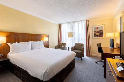 a hotel room with a large bed and a desk at Holiday Inn Newcastle Gosforth Park by IHG in Newcastle upon Tyne