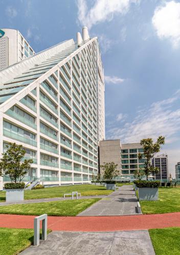 a large white building in front of a park at Casa Reforma by Kukun in Mexico City
