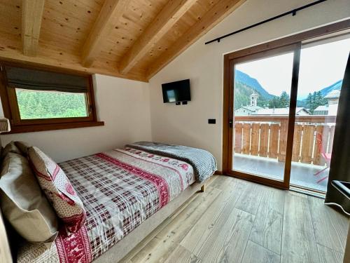 sypialnia z łóżkiem i dużym oknem w obiekcie Alpine Escape 1 w mieście Bormio