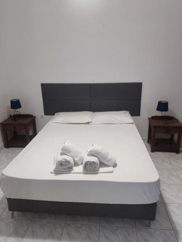 a white bed with two towels on top of it at ThalaSEA Apartments in Chrani