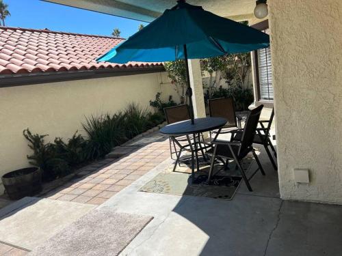 a patio with a table and chairs and an umbrella at Paradise resort living Mandalay beach in Oxnard