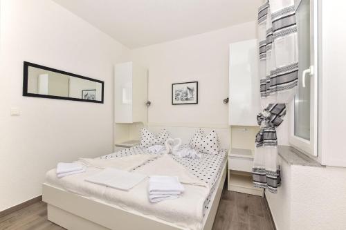 Dieses weiße Zimmer verfügt über ein Bett und einen Kühlschrank. in der Unterkunft Apartments Bernarda in Makarska