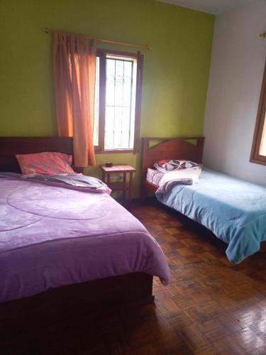 um quarto com 2 camas e uma janela em 悦来客栈 em Quito