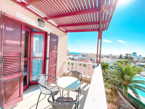 a patio with a table and chairs on a balcony at Villa Dima in Perissa