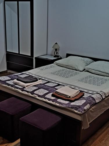 a bedroom with a large bed with purple cushions at Leśny Dworek - Apartamenty ze wspólnym salonem kominkowym i TV in Mrągowo