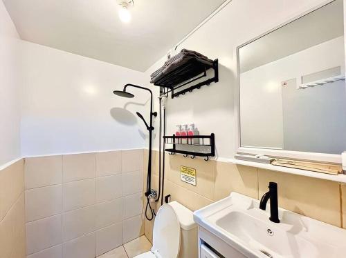 uma casa de banho com um lavatório, um espelho e um WC. em The RedRoom 1Bedroom Staycation em Anabu Primero