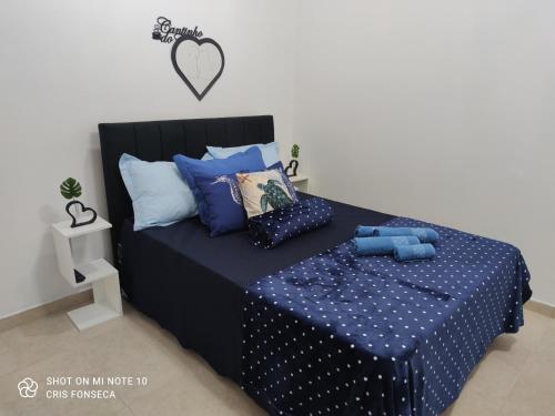 a bedroom with a bed with blue sheets and pillows at Hospedagem MAR SANTO in Florianópolis