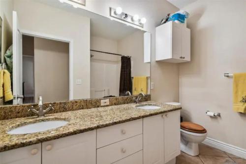 een badkamer met 2 wastafels en een toilet bij Bayview in Clearwater