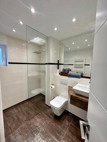 a bathroom with a toilet and a sink and a mirror at Seaside-Townhouse in Timmendorfer Strand