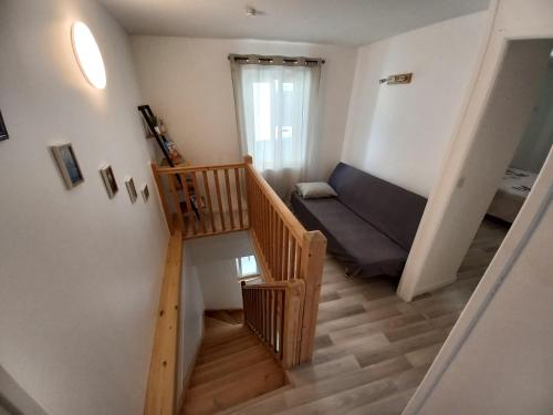 Cette petite chambre dispose d'un escalier et d'un canapé. dans l'établissement Maison à 5 minutes du lac à pied, à Aix-les-Bains