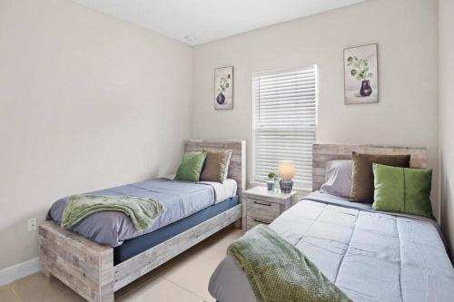 a bedroom with two beds and a window at Luxury and tranquility, In the Heart of Poinciana, just 30 min from Disney! in Poinciana