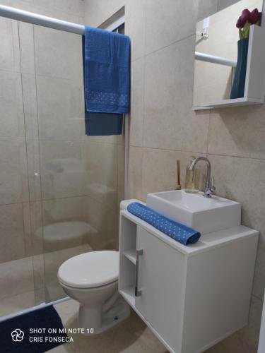 a white bathroom with a sink and a toilet at Hospedagem MAR SANTO in Florianópolis