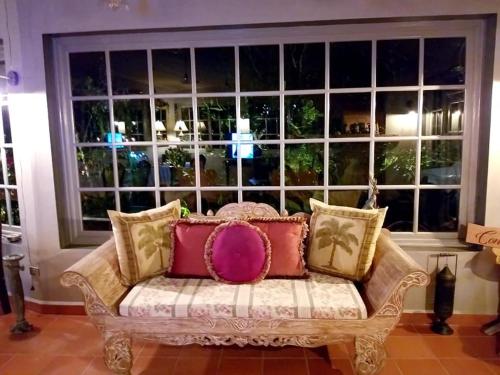 a couch with pillows sitting in front of a large window at SCHUMANN'S RESORT & PARK in Alto Boquete