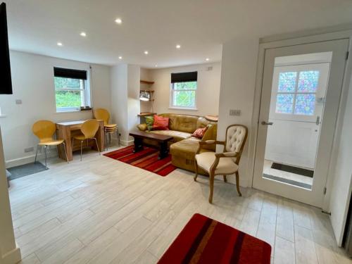a living room with a couch and a table at Spacious comfortable & private parking in town centre in Cheltenham