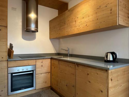 a kitchen with wooden cabinets and a stove top oven at Alpine Escape in Bormio