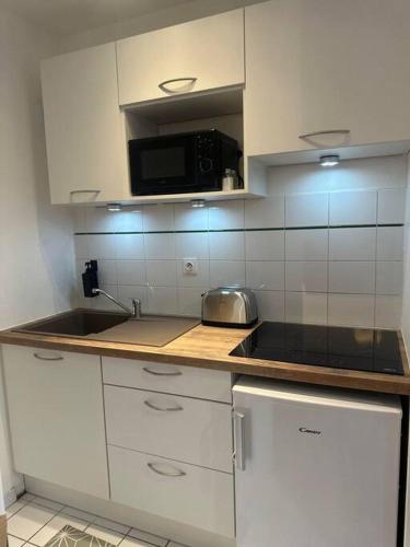 une cuisine avec un évier et un micro-ondes dans l'établissement Appartement neuf entièrement équipé proche centre, à Amiens