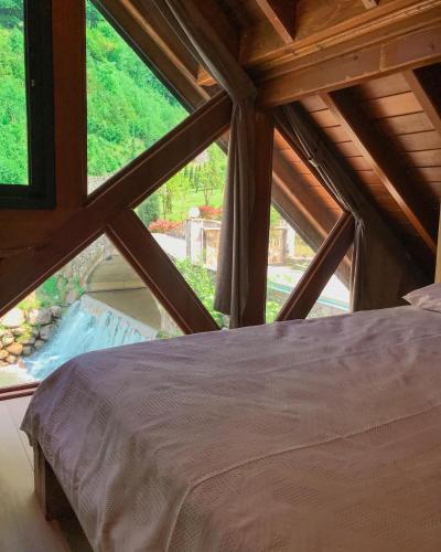 un letto in una camera con una grande finestra di timya sapanca a Sapanca